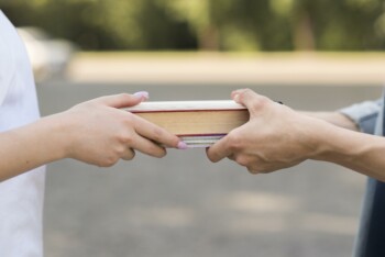 close up students exchanging book