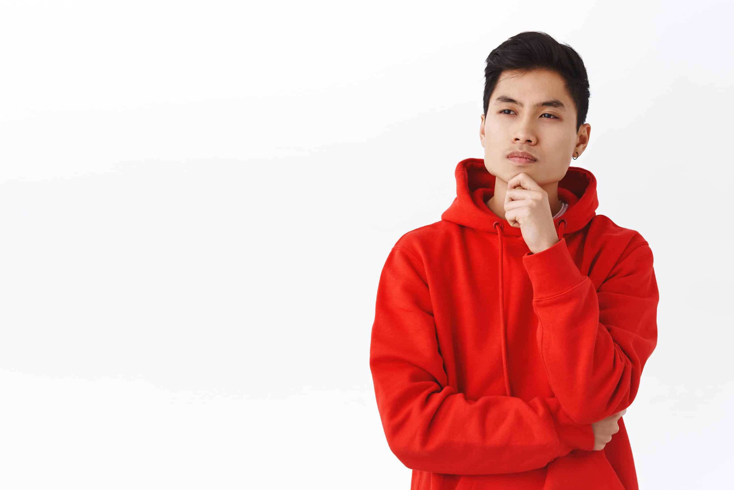 portrait of thoughtful young picky asian man facing choice, thin